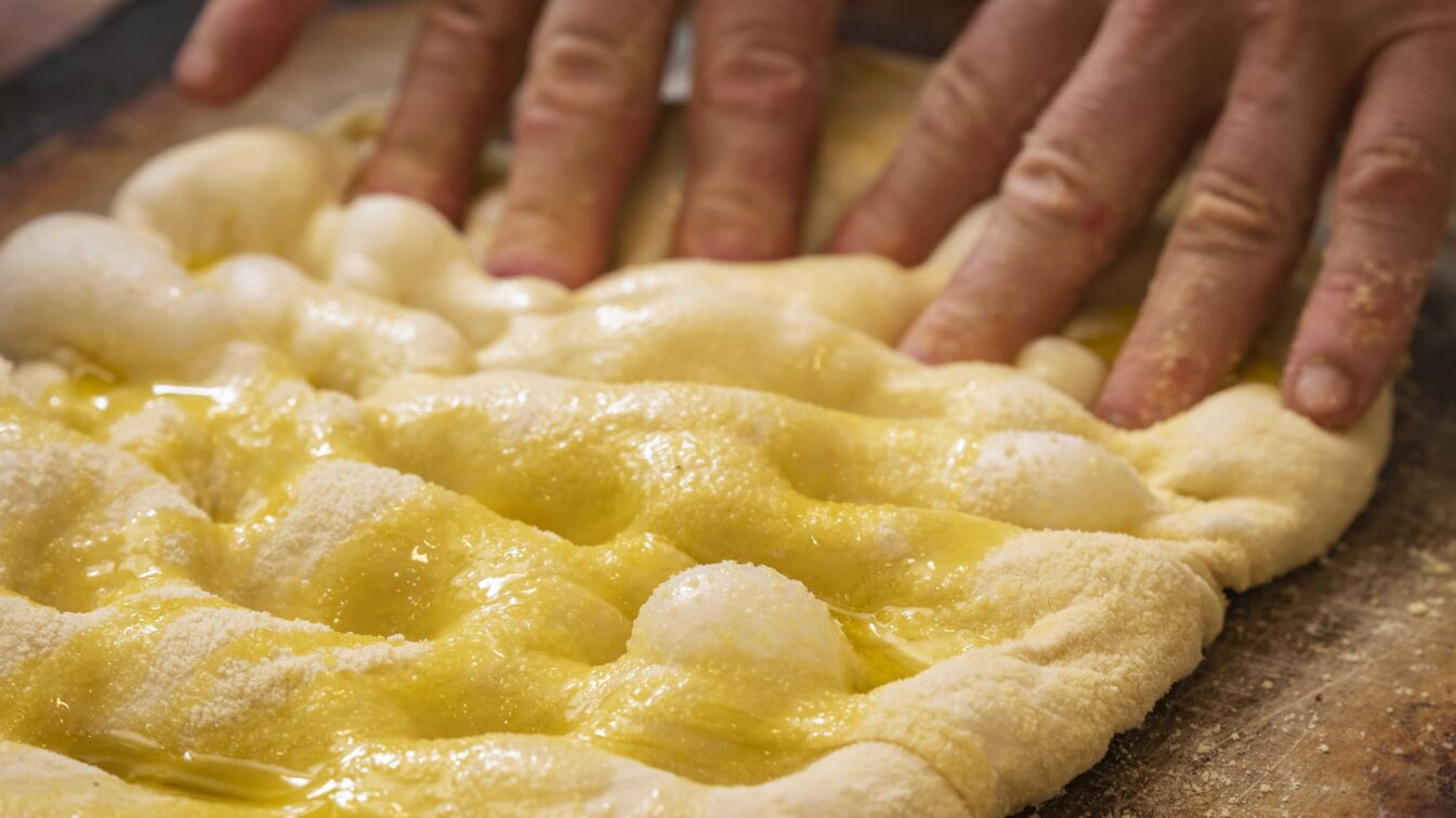 Panificatore che prepara una focaccia da Pattini Milano.