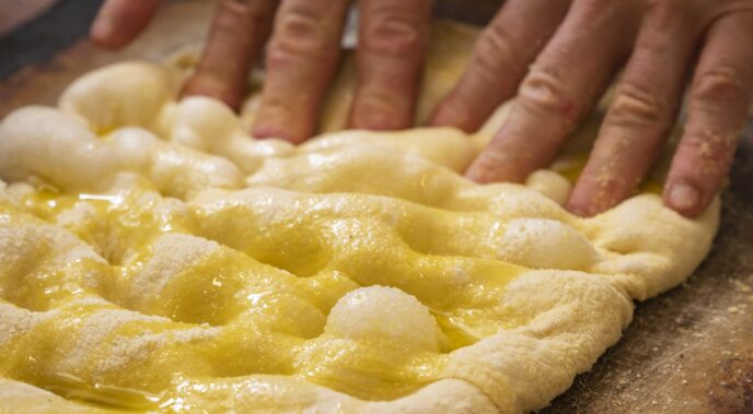 Panificatore che prepara una focaccia da Pattini Milano.
